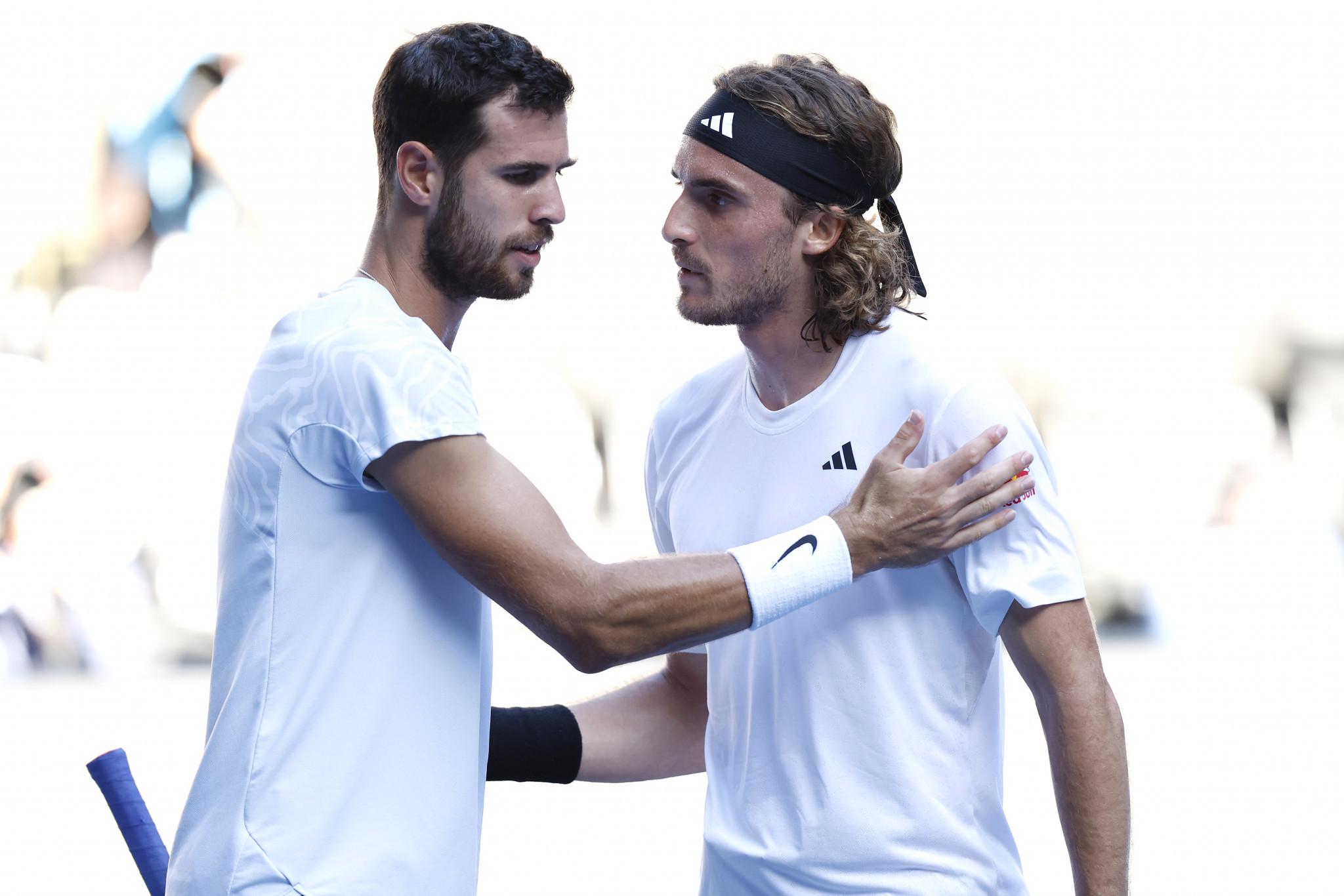 Karen Khachanov, left, and Stefanos Tsitsipas embrace at the net following their semi-final encounter at Melbourne Park ©Getty Images
