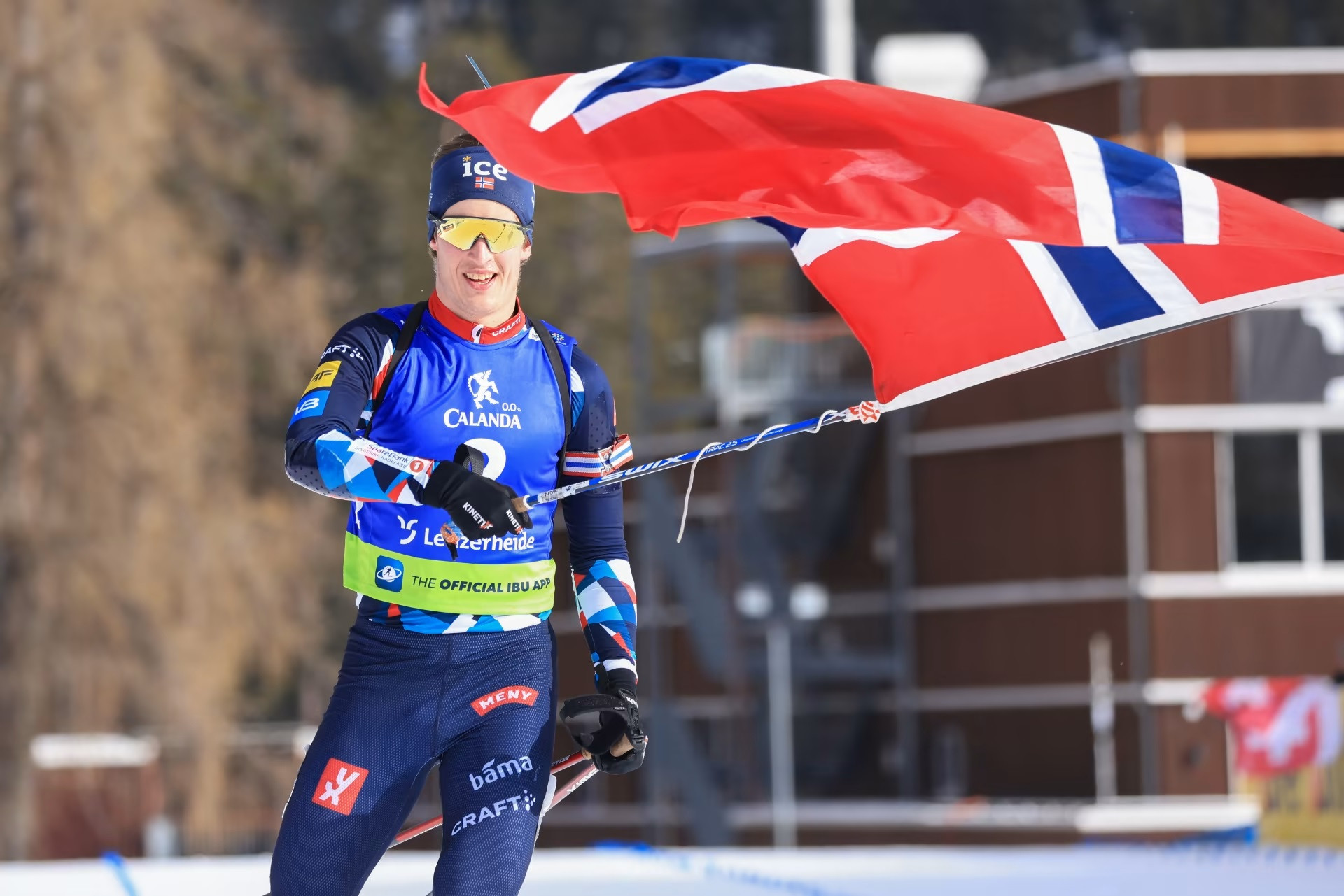 Vebjørn Sørum waves the Norwegian flag after sealing the men's 12.5km pursuit title ©IBU