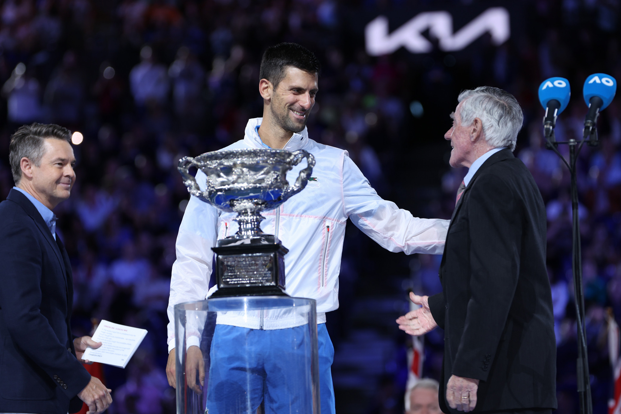 Novak Djokovic prepares to receive the Australian Open trophy from Ken Rosewall ©Getty Images