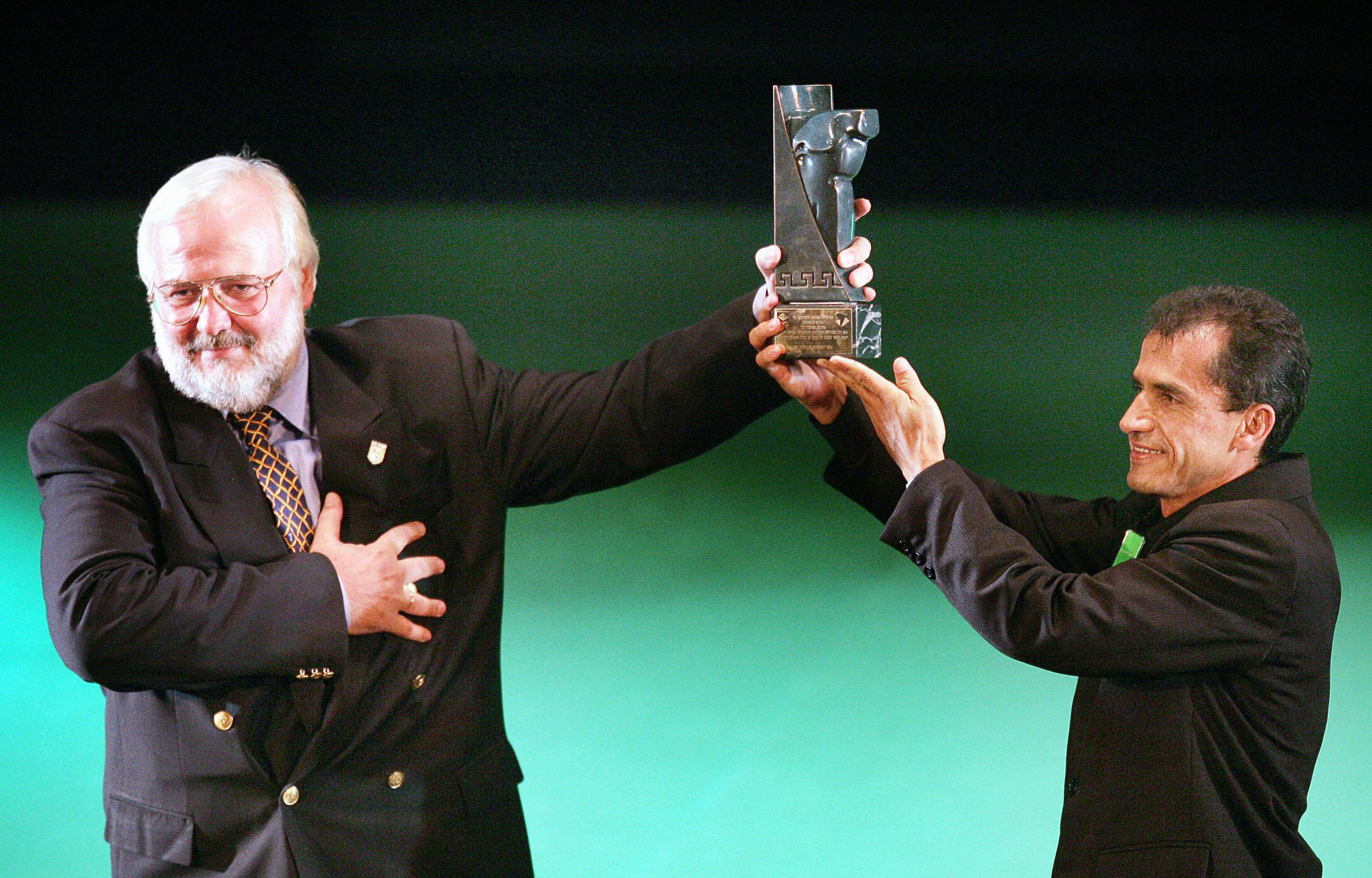 Polyvios Kossivas, left, received the 2004 Prêmio Brasil Olímpico from Athens 2004 marathon bronze medallist Vanderlei de Lima for his actions which helped him after he was attacked during the race ©Getty Images