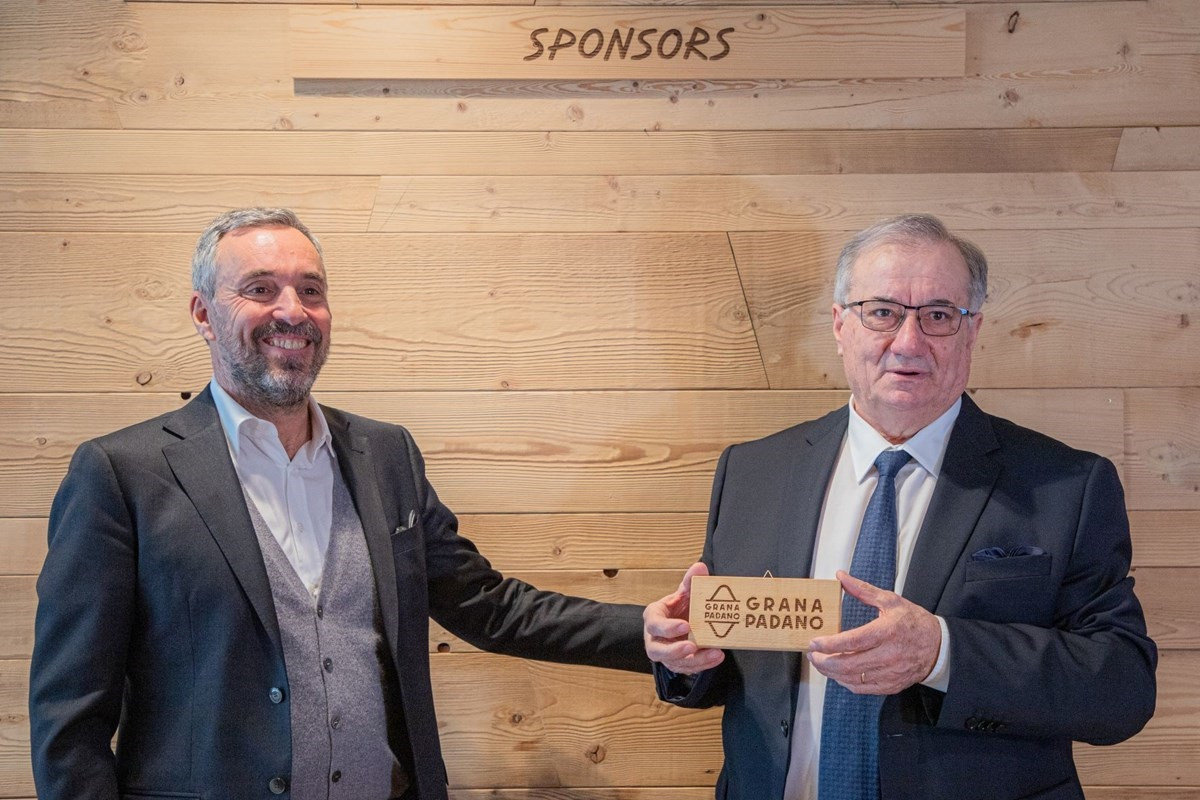 Milan Cortina 2026 chief executive Andrea Varnier, left, celebrates the new sponsorship deal with Renato Zaghini, head of the Grana Padano Protection Consortium, right, at a special event ©Milan Cortina 2026