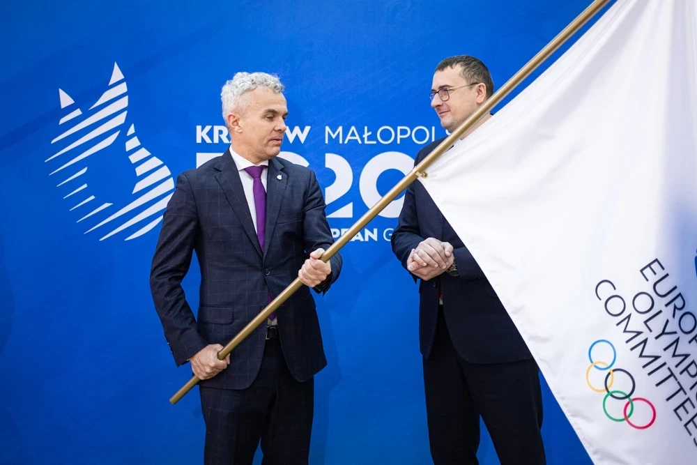 Krynica-Zdrój Mayor Piotr Ryba, right, received a flag from Organising Committee chief Marcin Nowak ©Kraków-Malopolska 2023 