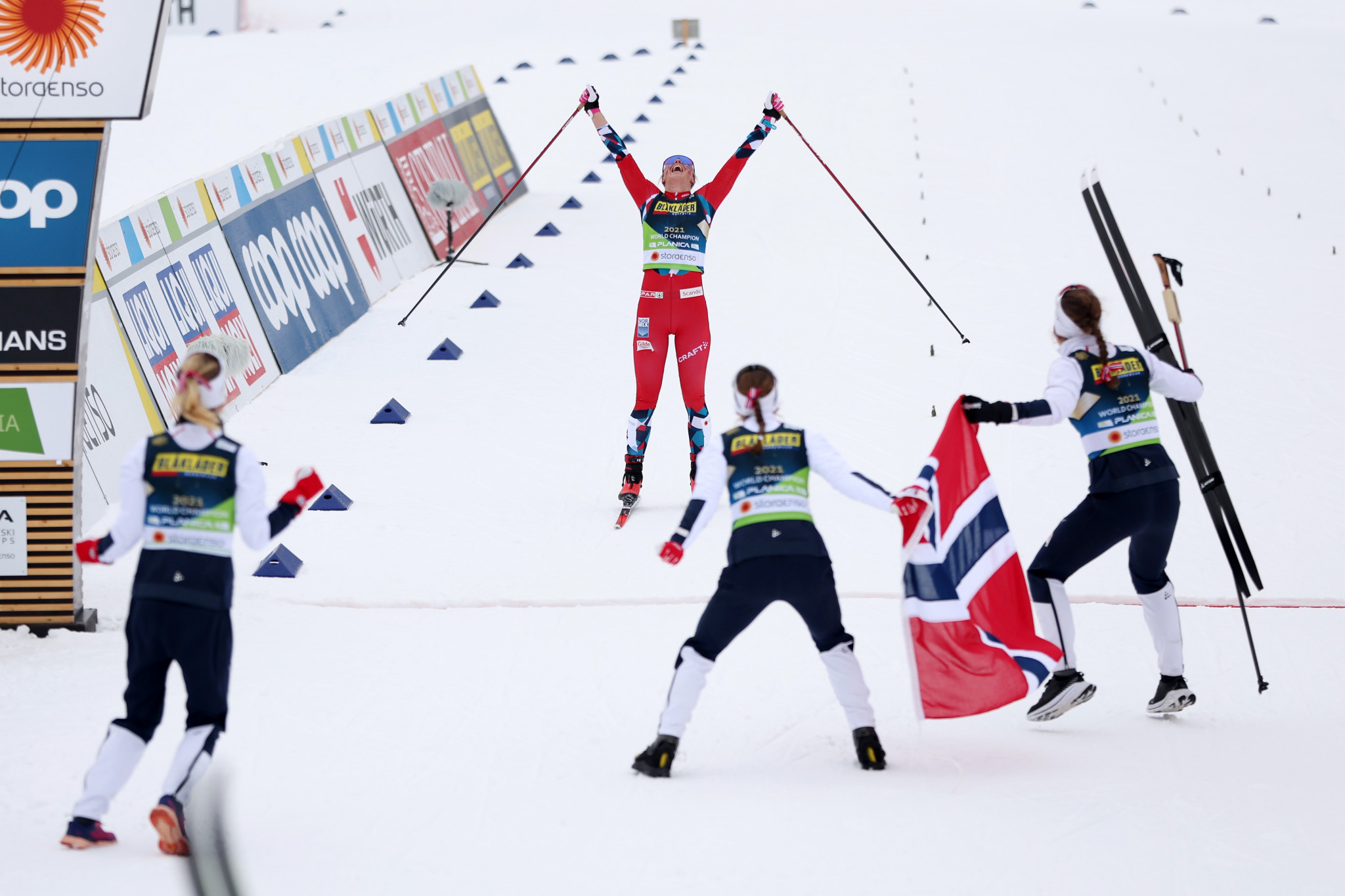 Anne Kjersti Kalvå crosses the finish line as her team-mates join her to celebrate their victory ©Getty Images
