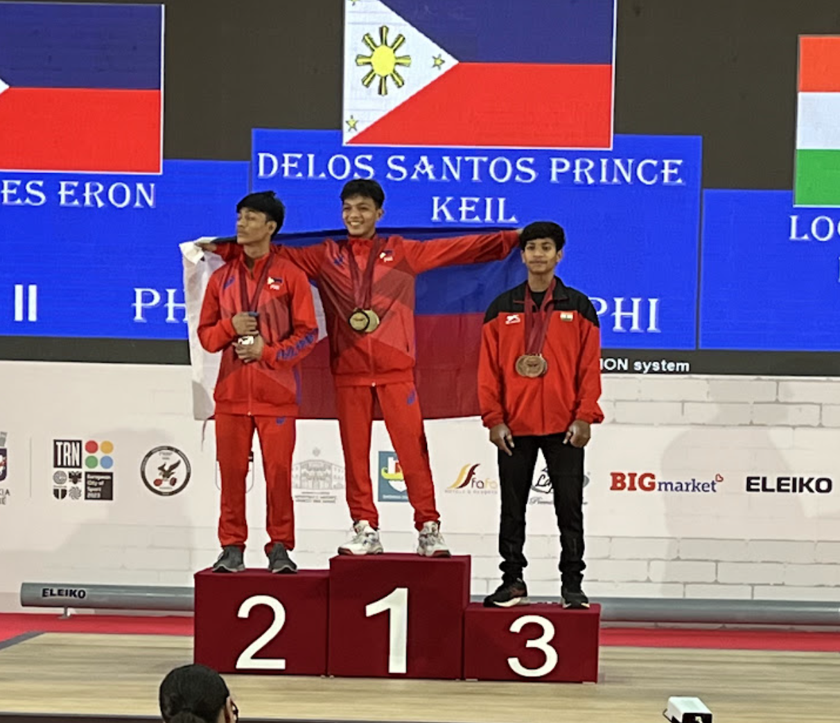 Keil Delos Santos, centre, won the men's 49kg on a good day for The Philippines as team-mate  Eron Borres, left, took the silver medal ©IWF