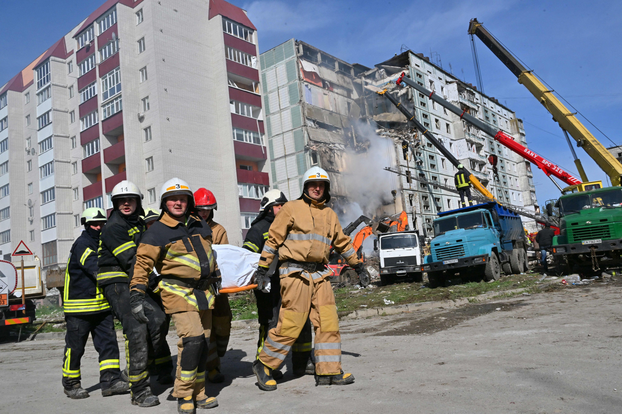 Rescuers carry a bag containing a body next to damaged residential buildings in Uman after Russian missile strikes targeted several Ukrainian cities today ©Getty Images