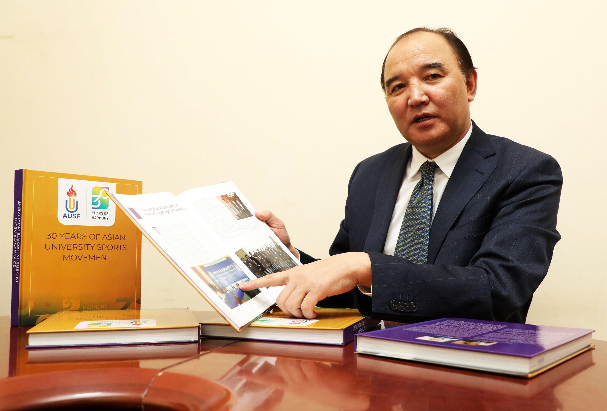 Dr Dorjsuren Jargalsaikhan, the Asian University Sports Federation vice-president, pictured with the book he co-wrote marking the organisation's 30th anniversary ©MSSF