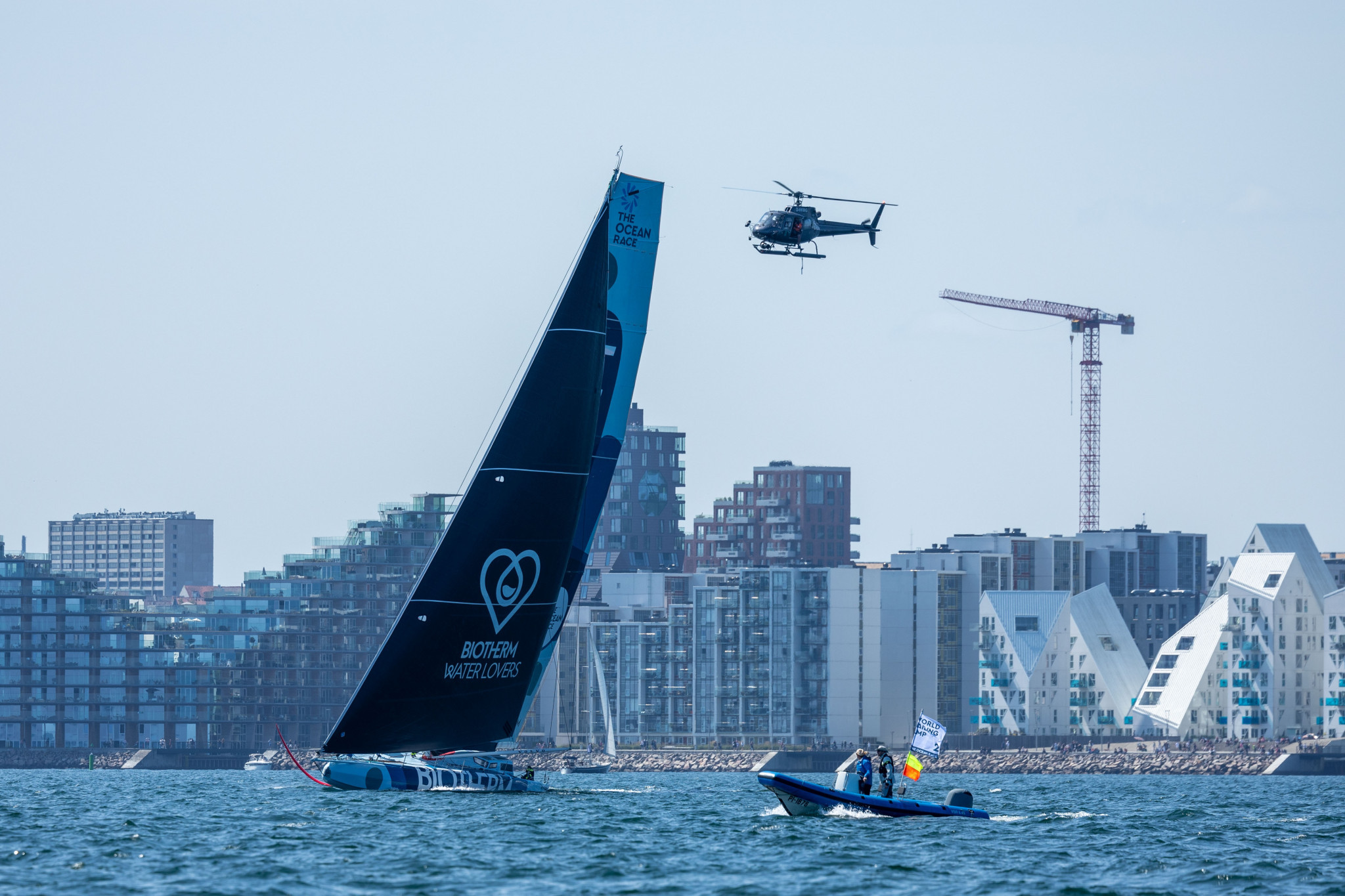 A helicopter tracks the IMOCA in-port race staged against the backdrop of Aarhus' stunning architecture ©Peter Broegger