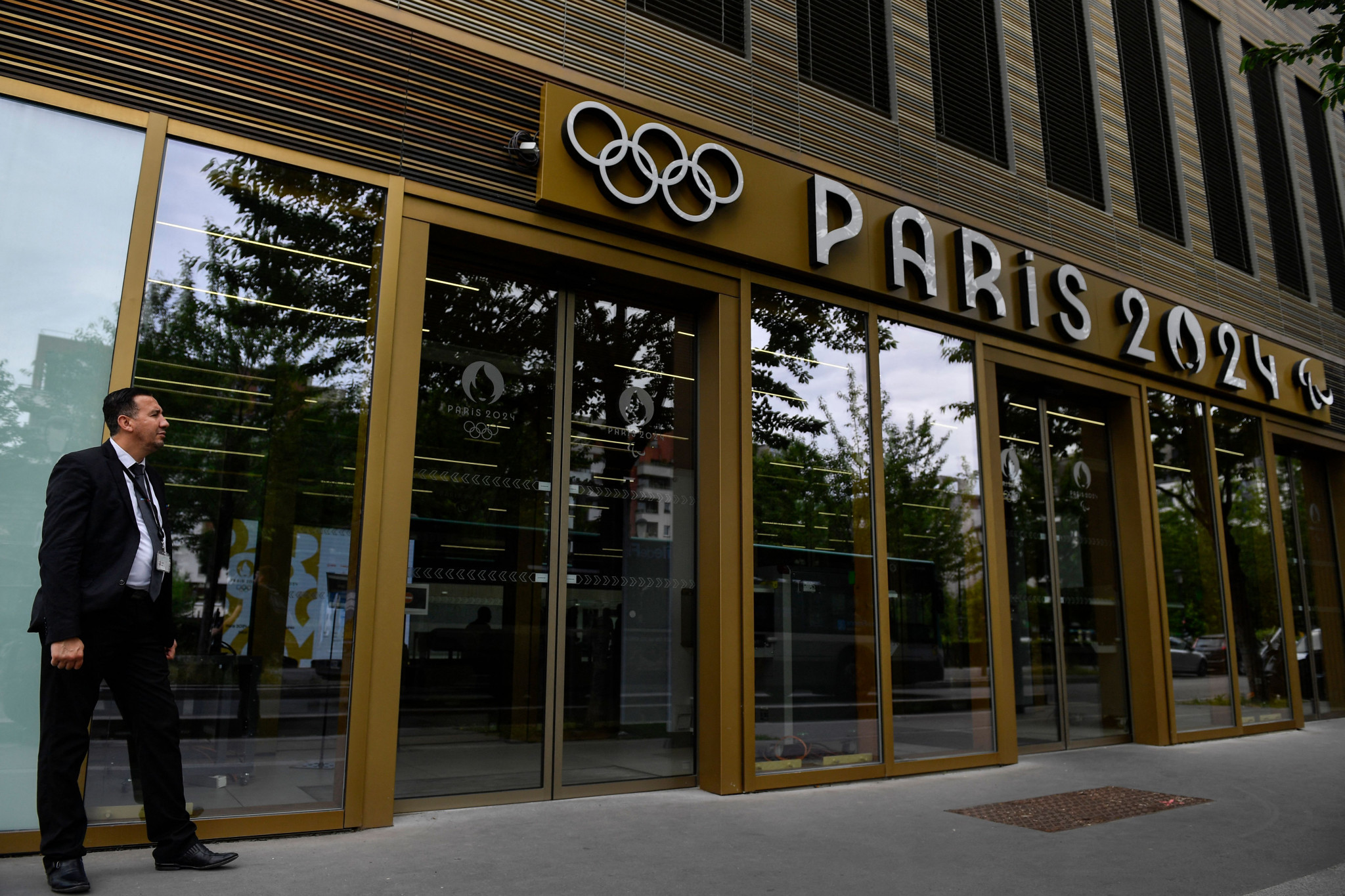 A security official stands at the entrance of the Paris 2024 headquarters following today's raid ©Getty Images