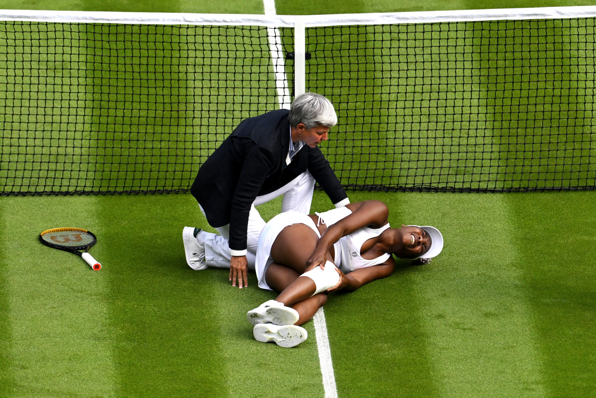 Venus Williams is comforted by the umpire after a nasty fall during her match at Wimbledon against fellow wildcard Elina Svitolina ©Getty Images