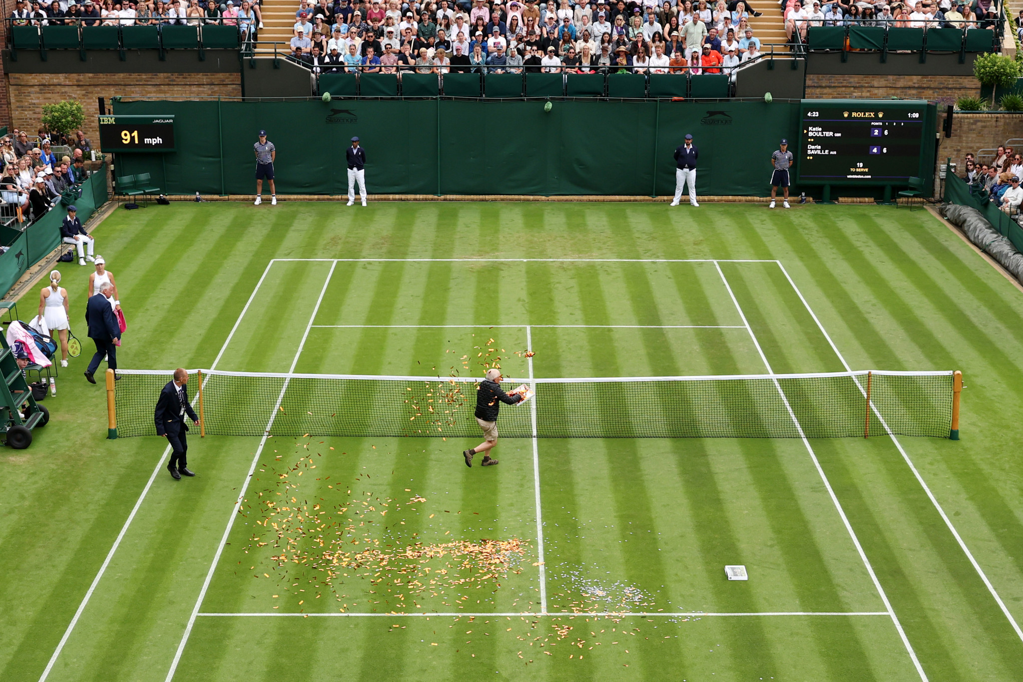 A Just Stop Oil protester interrupts play on Court 18 for a second time by throwing confetti and jigsaw puzzle pieces on to court ©Getty Images