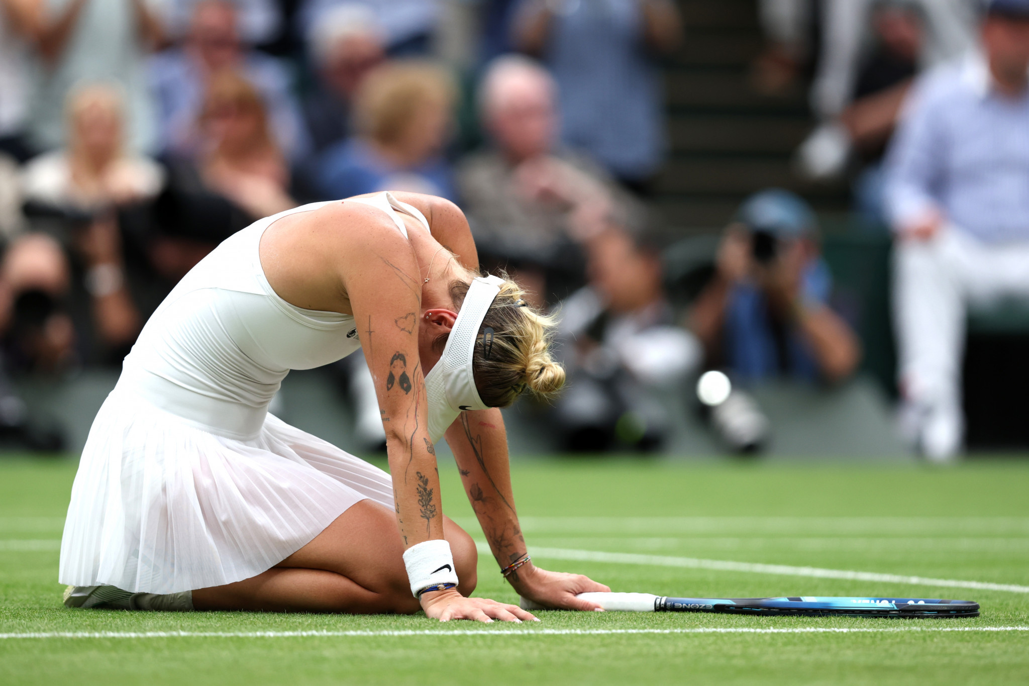 An emotional Markéta Vondroušová goes to the ground after becoming the first unseeded player in the open era to win the Wimbledon, defeating Ons Jabeur for the women's singles title ©Getty Images
