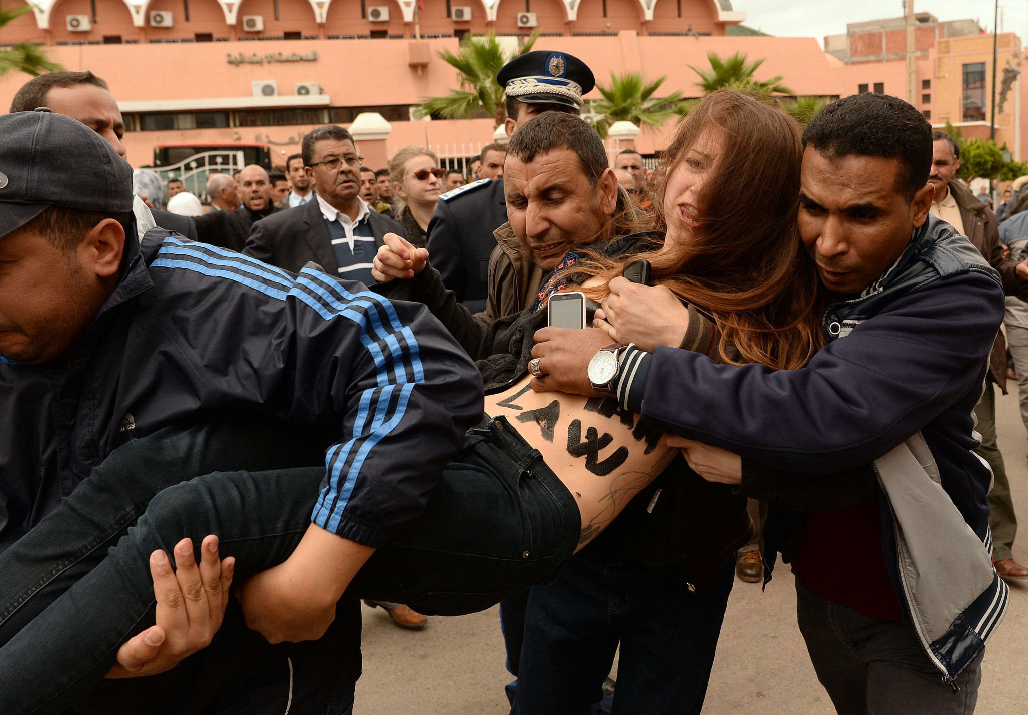 An activist is taken away by undercover Moroccan policemen in 2016 during a hearing in the trial of a man accused of homosexuality which is punishable in the country by up to three years in jail ©Getty Images