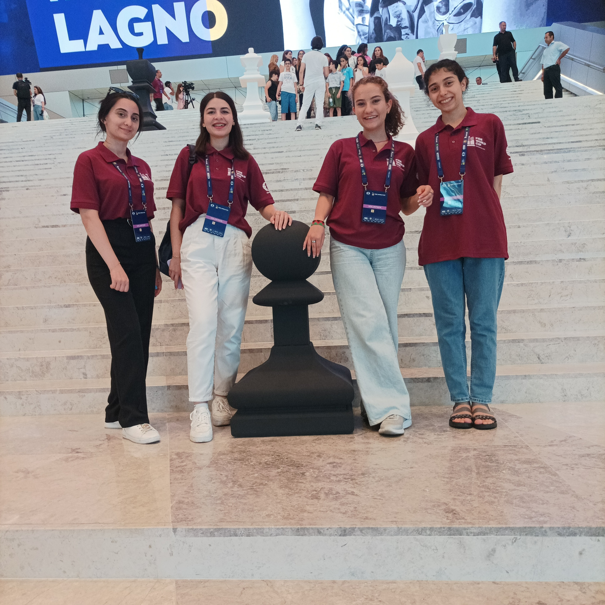Volunteers pose with a giant pawn at the 2023 FIDE World Cup in Baku ©ITG