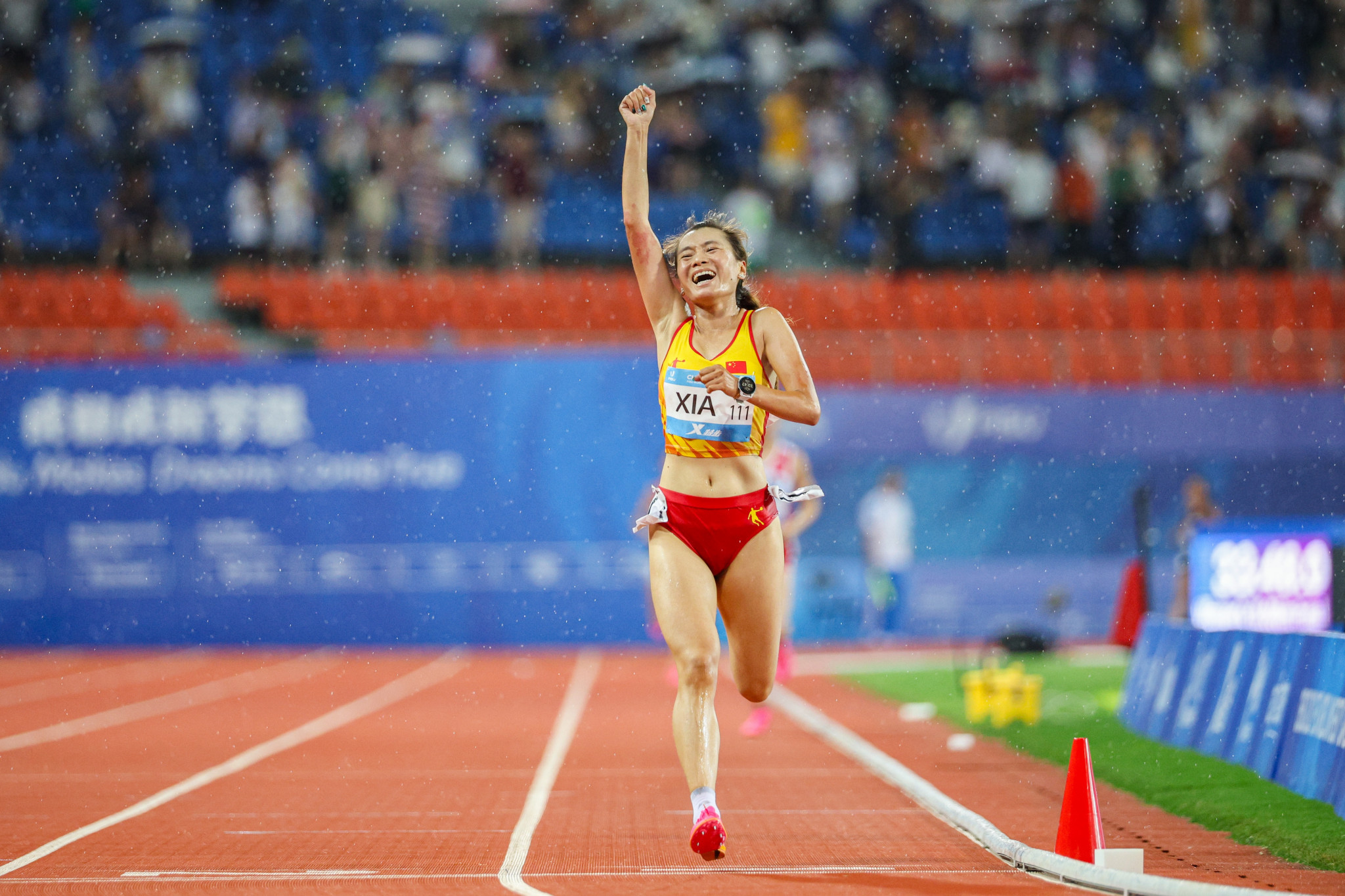Xia Yuyu of China celebrates after crossing the finish line to win the women's 10,000m crown ©Chengdu 2021