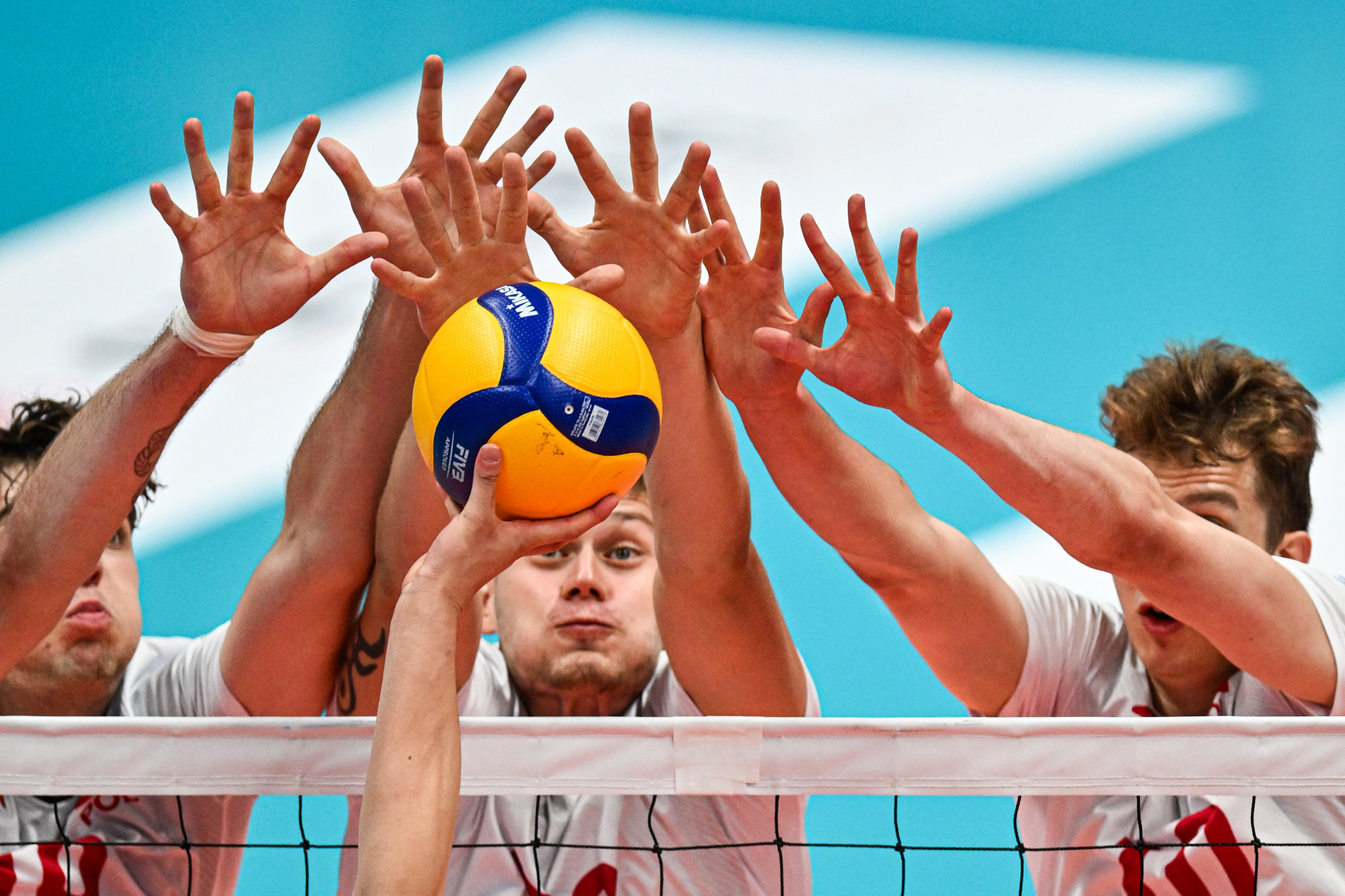 Poland's players form a defensive barrier at the net during their volleyball match against the Republic of Korea ©FISU
