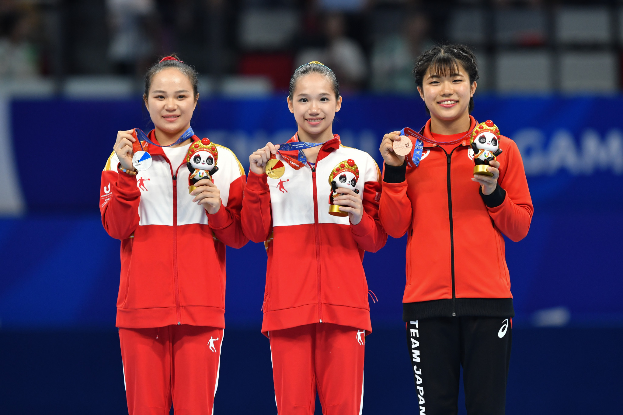 China’s Ou Yushan, centre, stands at the top of the women's balance beam podium ©Chengdu 2021