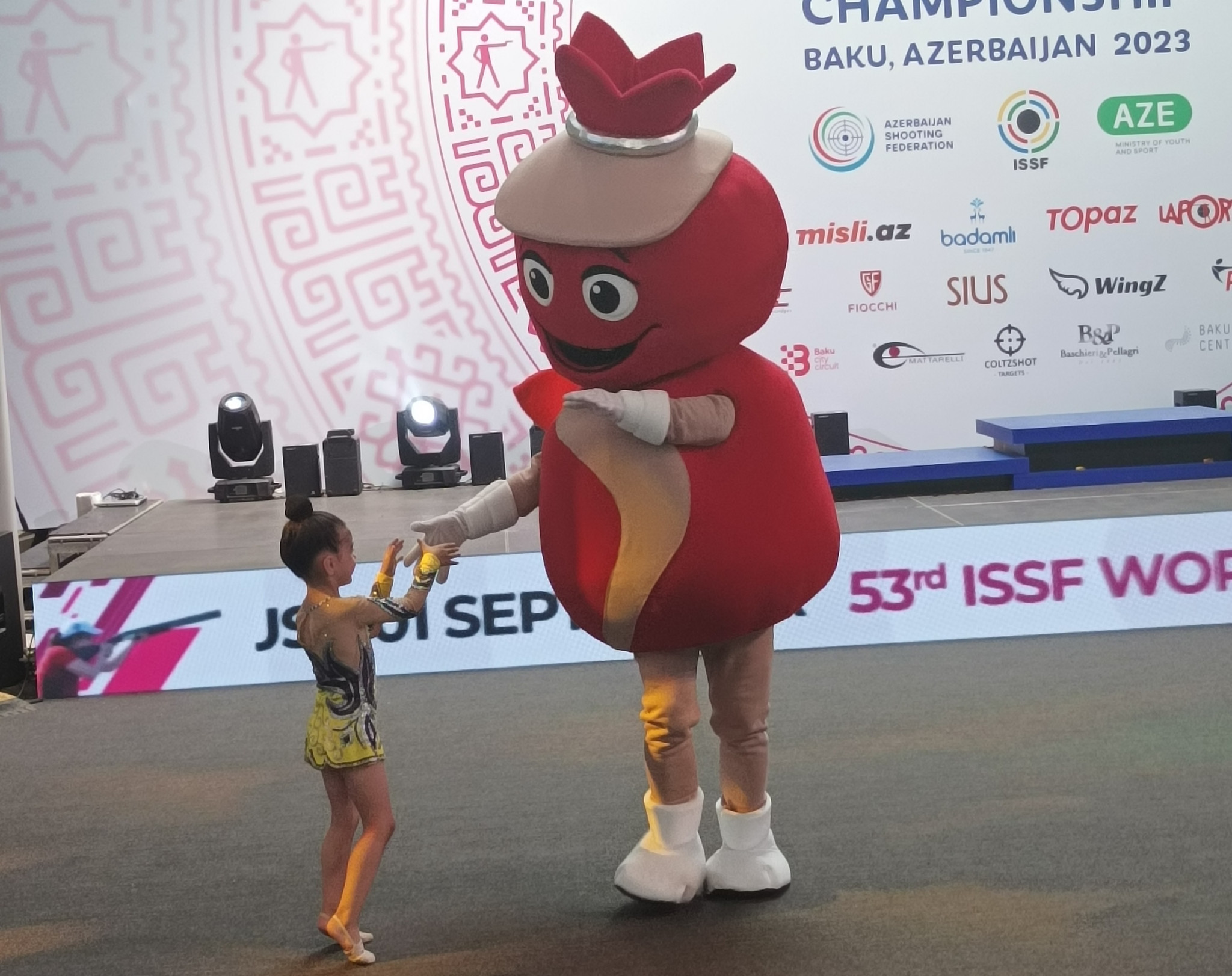 A very young gymnast dances with Baku 2023 mascot Targy ©ITG