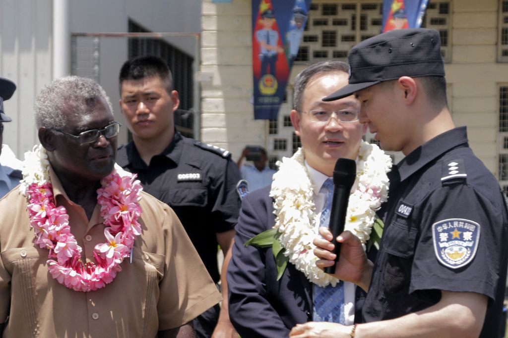 Solomon Islands Prime Minister Manasseh Sogavare, left, looks on with Li Ming, second right, China's ambassador to the Solomon Islands, as they listen to a Chinese police officer during a ceremony in Honiara on November 4 2022, following the donation of water cannons ©Getty Images

