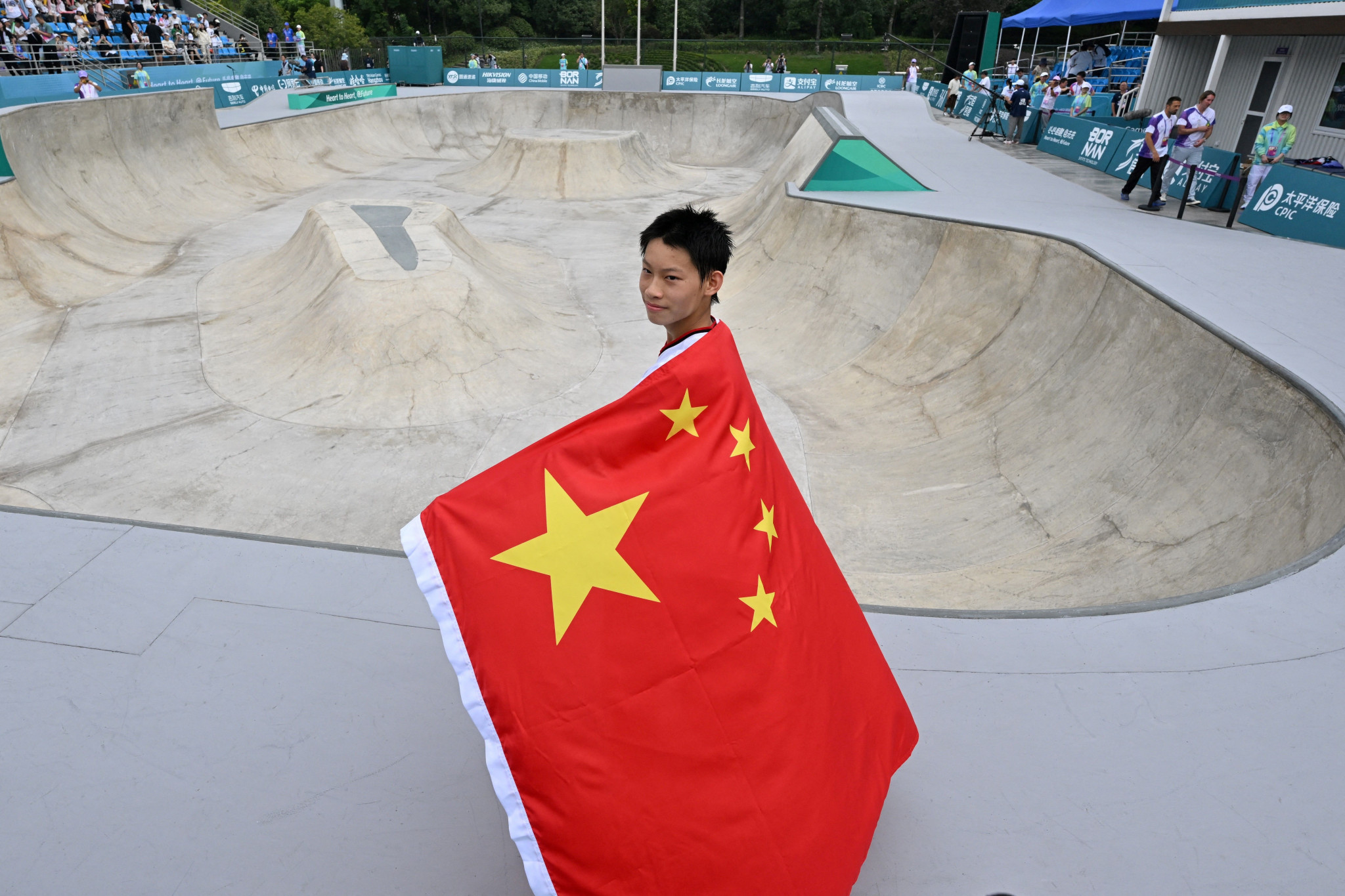 China's Chen Ye displays his national flag after winning the men's park skateboarding title ©Getty Images