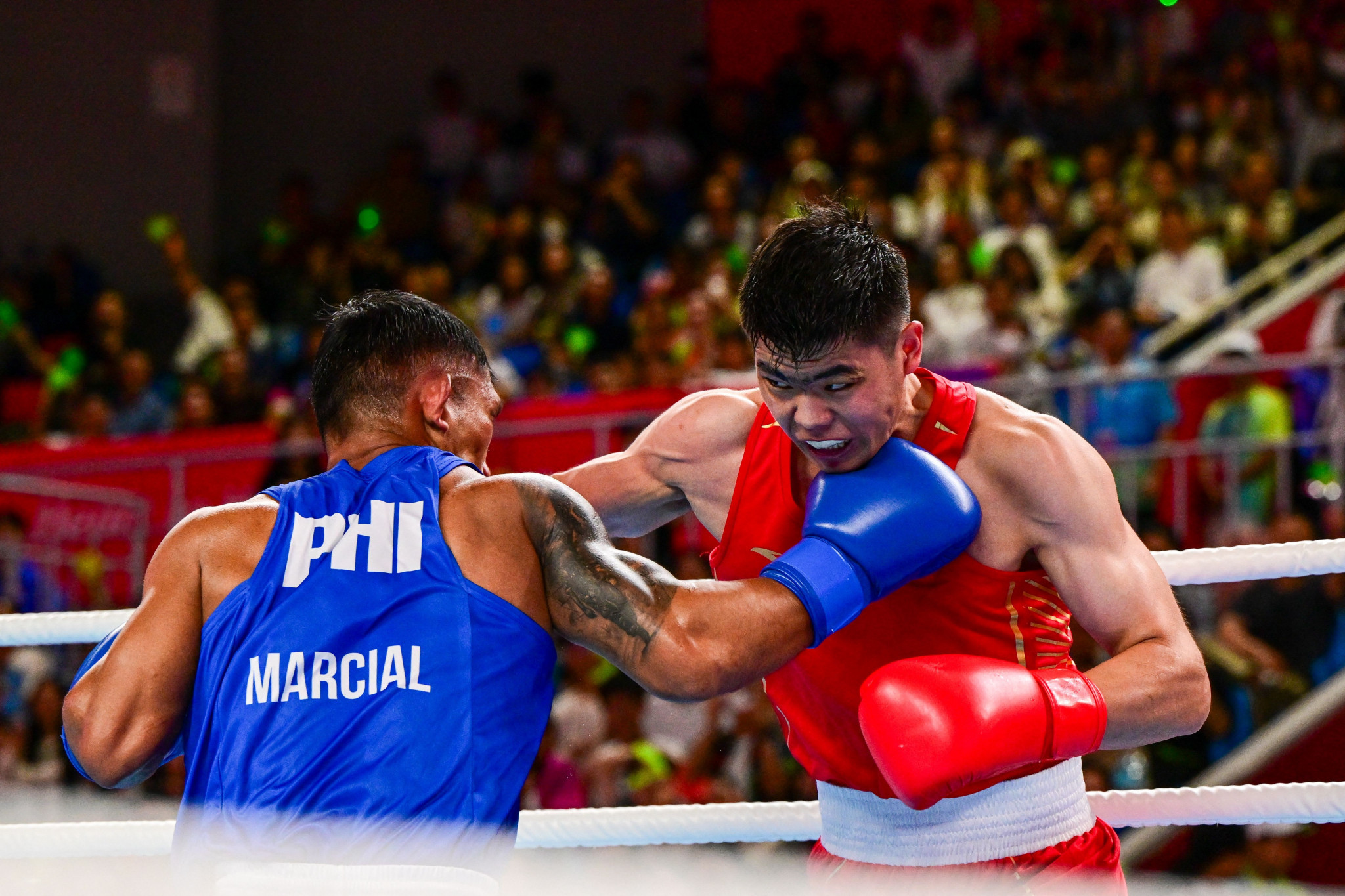 Tuohetaerbieke Tanglatihan, right, delighted the Chinese crowd with his comeback triumph against Filipino Olympic bronze medallist Eumir Marcial, right ©Getty Images