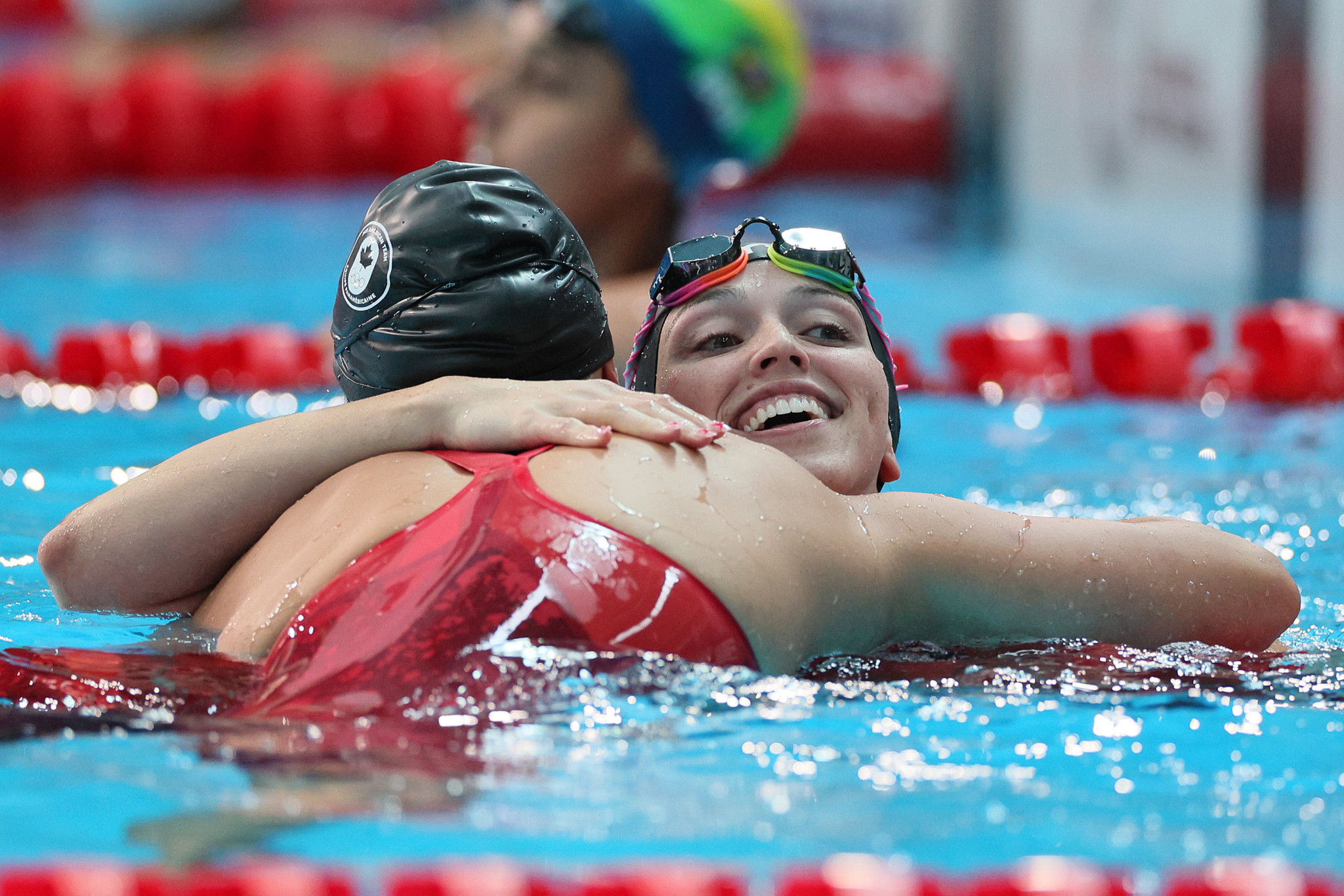 The United States' Gabi Albiero embraces Canada's Maggie MacNeil after their shared gold in the 50m freestyle ©Getty Images