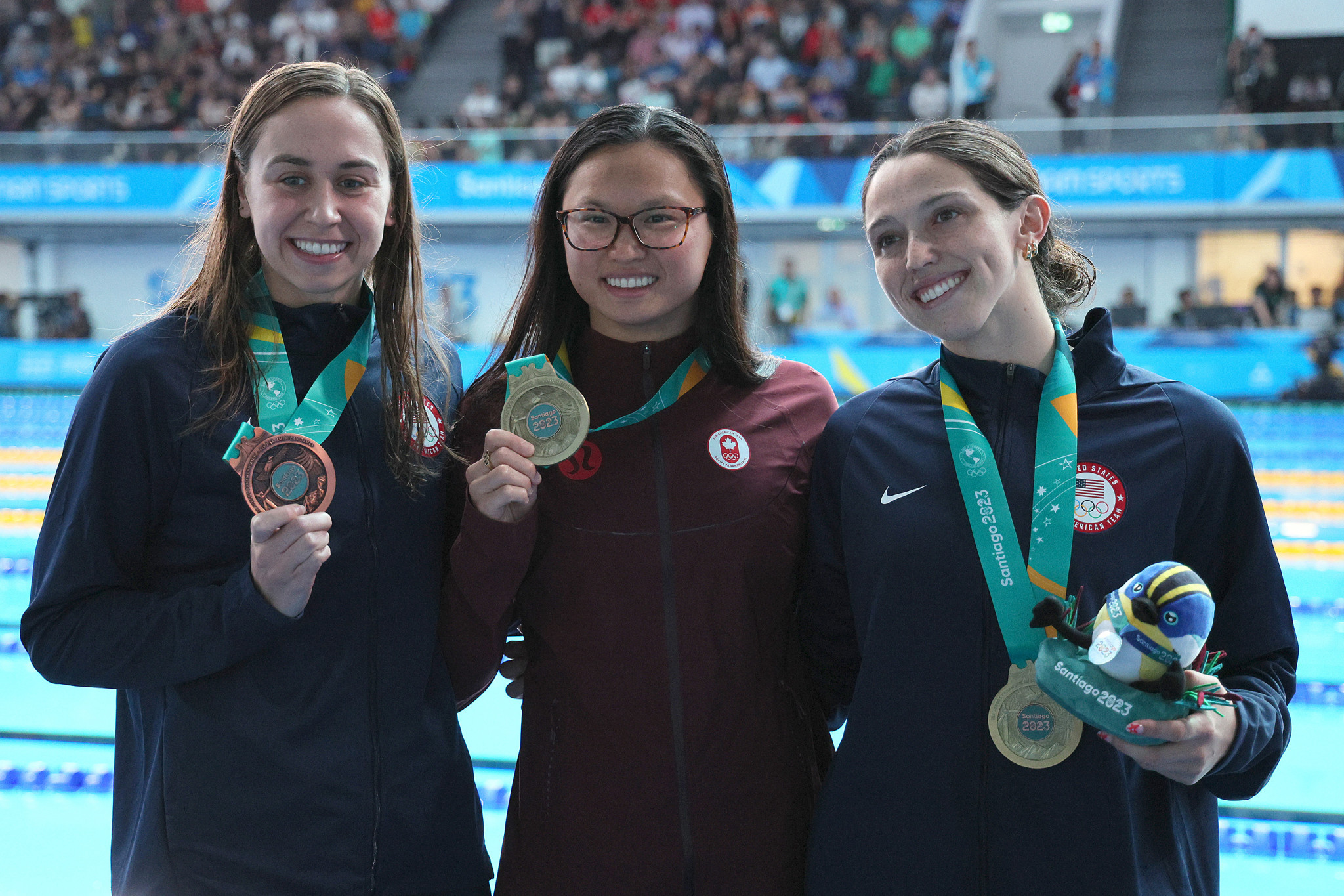  Maggie MacNeil, centre, and Gabi Albiero, right, both won gold after a tie in the women's 50m freestyle ©Getty Images