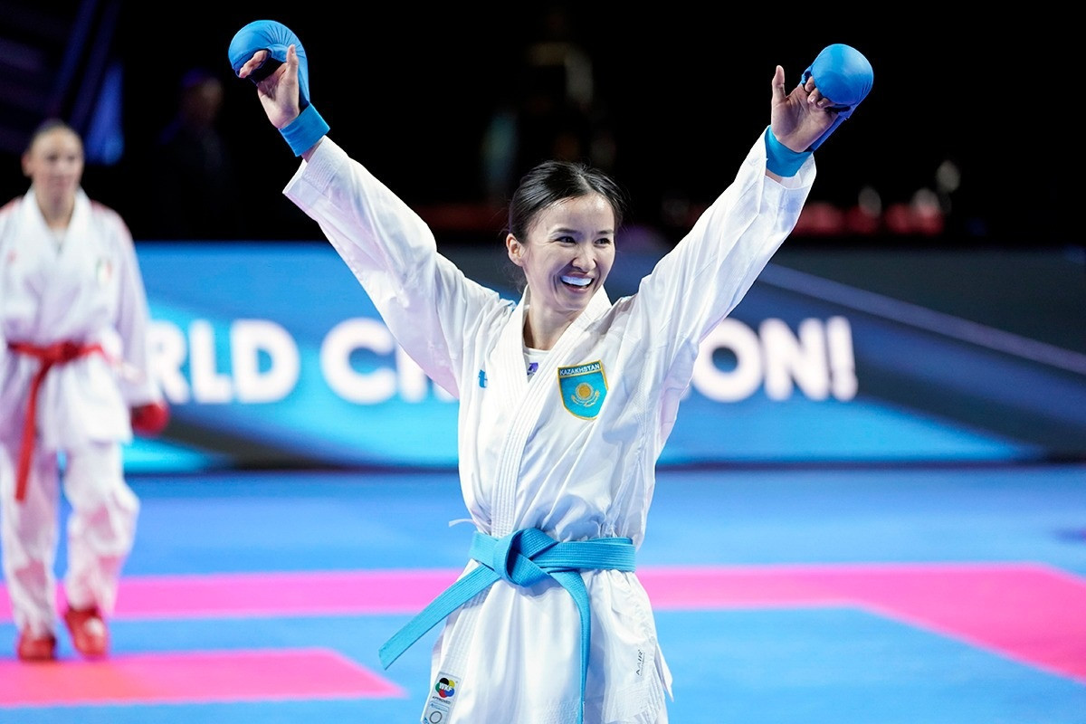 Kazakhstan’s Moldir Zhangbyrbay raises her arms in celeration after sealing women’s under-50kg gold ©WKF