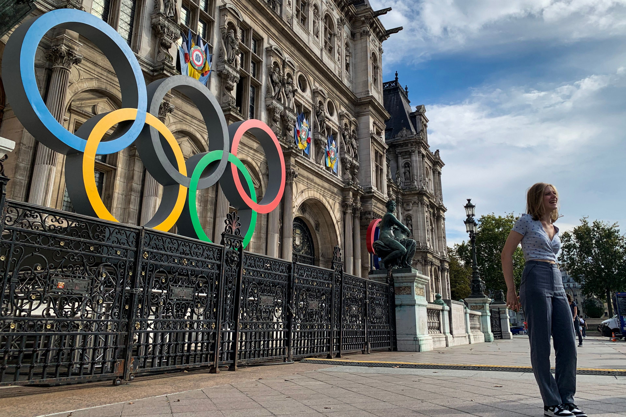 A woman poses in front of the Olympic Rings at the Hotel De Ville in Paris, the city that will host the 2024 Olympic and Paralympic Games. ©Getty Images