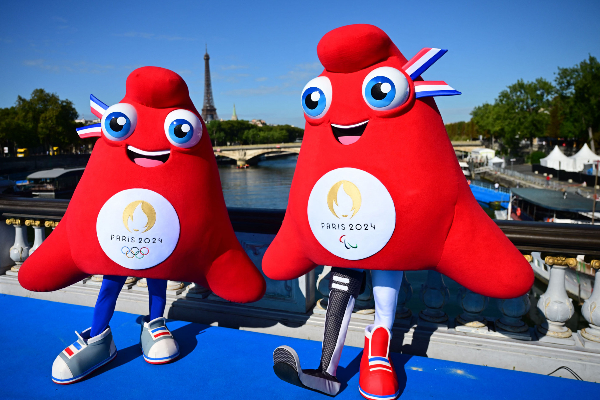Olympic Phryges mascots pose for a photograph on the Alexandre III bridge with the Eiffel Tower in the background, © Getty Images