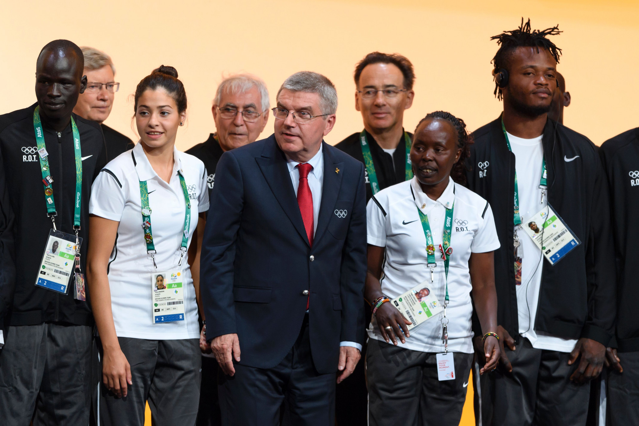 International Olympic Committee (IOC) President Thomas Bach (C) poses with a team of Refugee Olympic Athletes and their trainers during the 129th IOC session in Rio de Janeiro on August 2, 2016. © Getty Images