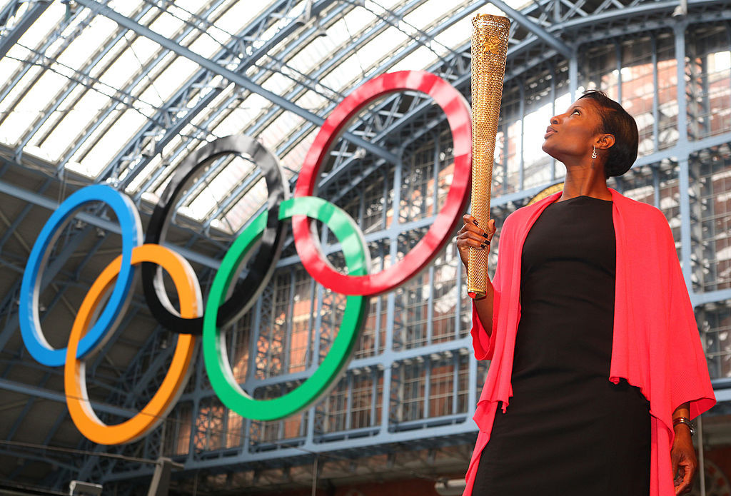 Denise Lewis poses with the 2012 London Olympic Torch at St Pancras International Rail Station. © Getty Images