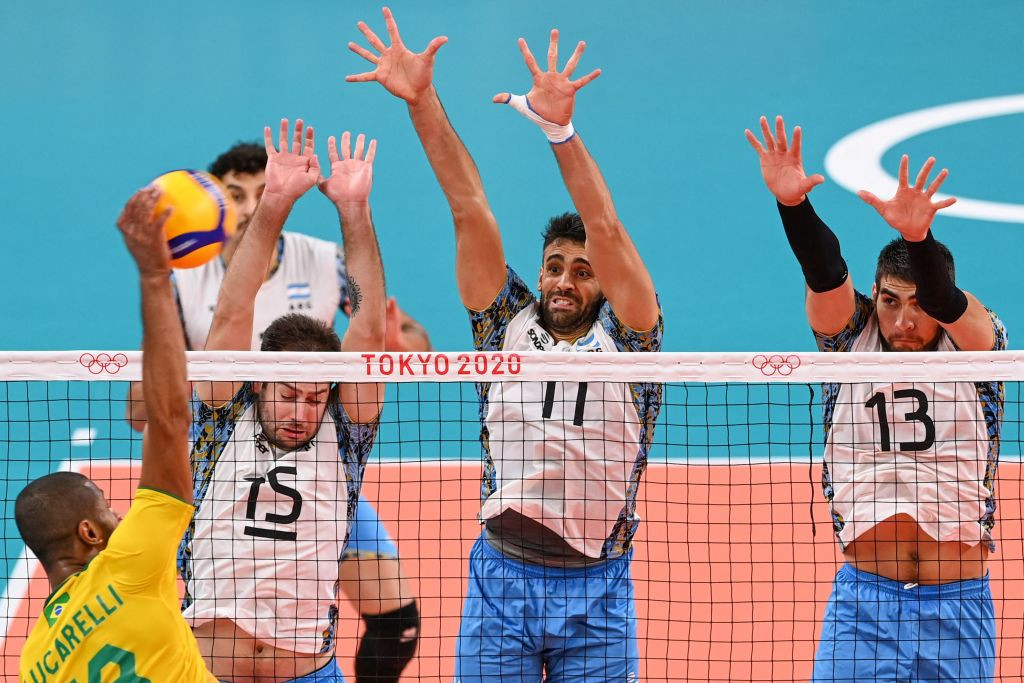 Ricardo Souza hits the ball in front of Argentina's Luciano de Cecco, Sebastian Sole and Ezequiel Palacios in the men's bronze medal volleyball match between Argentina and Brazil during the Tokyo 2020. GETTY IMAGES