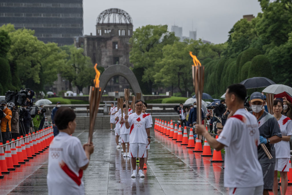 Torchbearers carry the Tokyo 2020 Olympic torch during a relay in Hiroshima, Japan. GETTY IMAGES
