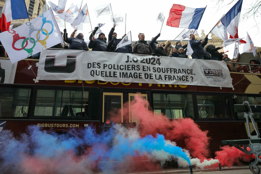 Demonstrators wave flags in a bus with the  banner 'Police officers suffering, what image of France?' GETTY IMAGES