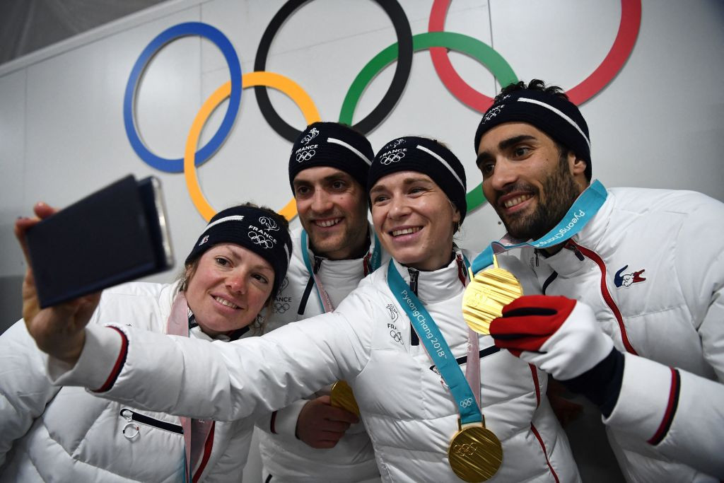 France's biathlon gold medallists Marie Dorin, Simon Desthieux, Anais Bescond and Martin Fourcade pose for a selfie. GETTY IMAGES