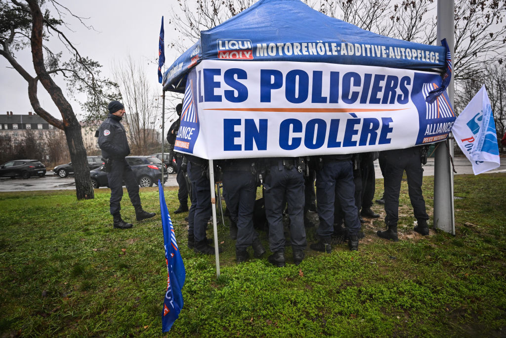 Police officers stand under a tent in support of a demonstration organised by colleagues on the Bridge of Europe, in Strasbourg. GETTY IMAGES