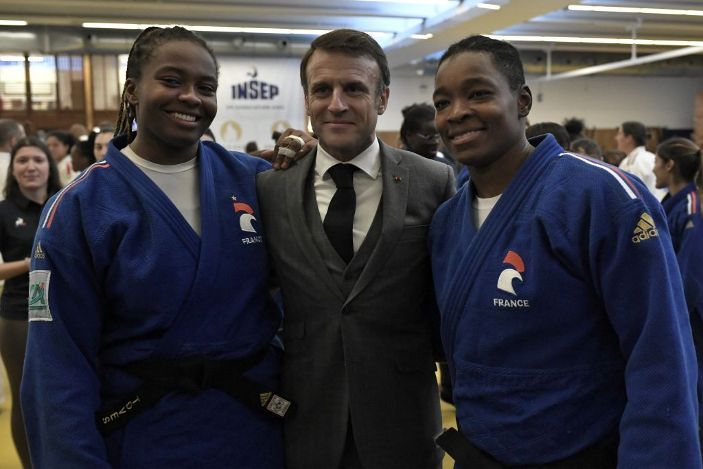 French President Emmanuel Macron poses with judokas Romane Diko and Audrey Tcheumeo. GETTY IMAGES