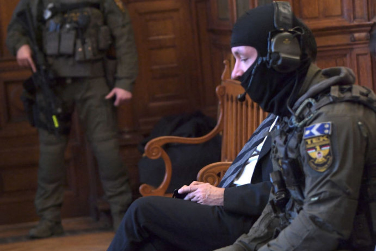 Tamás Gyárfás, guarded by a policeman in the dock of the court. GETTY IMAGES
