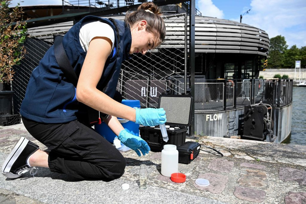 An employee collects a sample of water from the Seine to analyse its composition ahead of the Paris 2024 near the Pont Alexandre III in Paris on August 2023. GETTY IMAGES