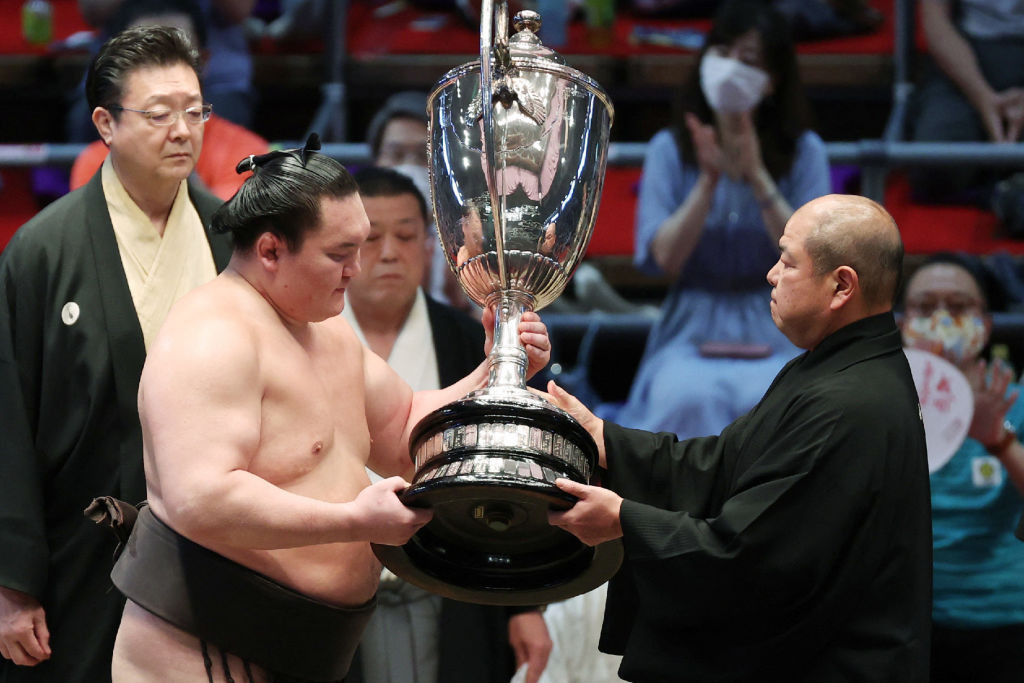 Hakuho receives the championship trophy  to finish with a perfect 15-0 record for his 45th career tournament in Nagoya on 18 July 2021. GETTY IMAGES 