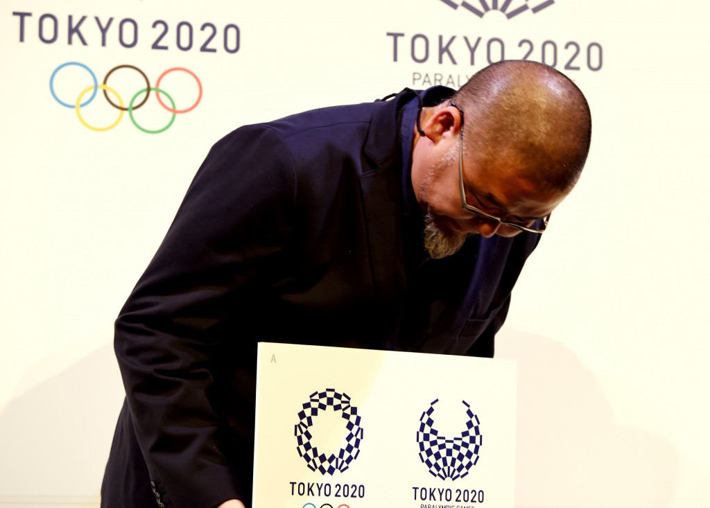 Japanese designer Asao Tokolo bows while holding his selected Tokyo 2020 logo at a special ceremony ©Getty Images