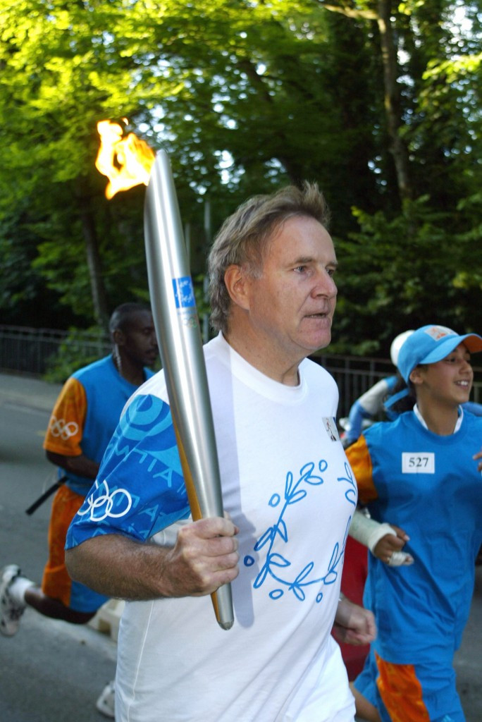 Denis Oswald pictured carrying the Olympic Torch through Lausanne ahead of Athens 2004 ©Getty Images