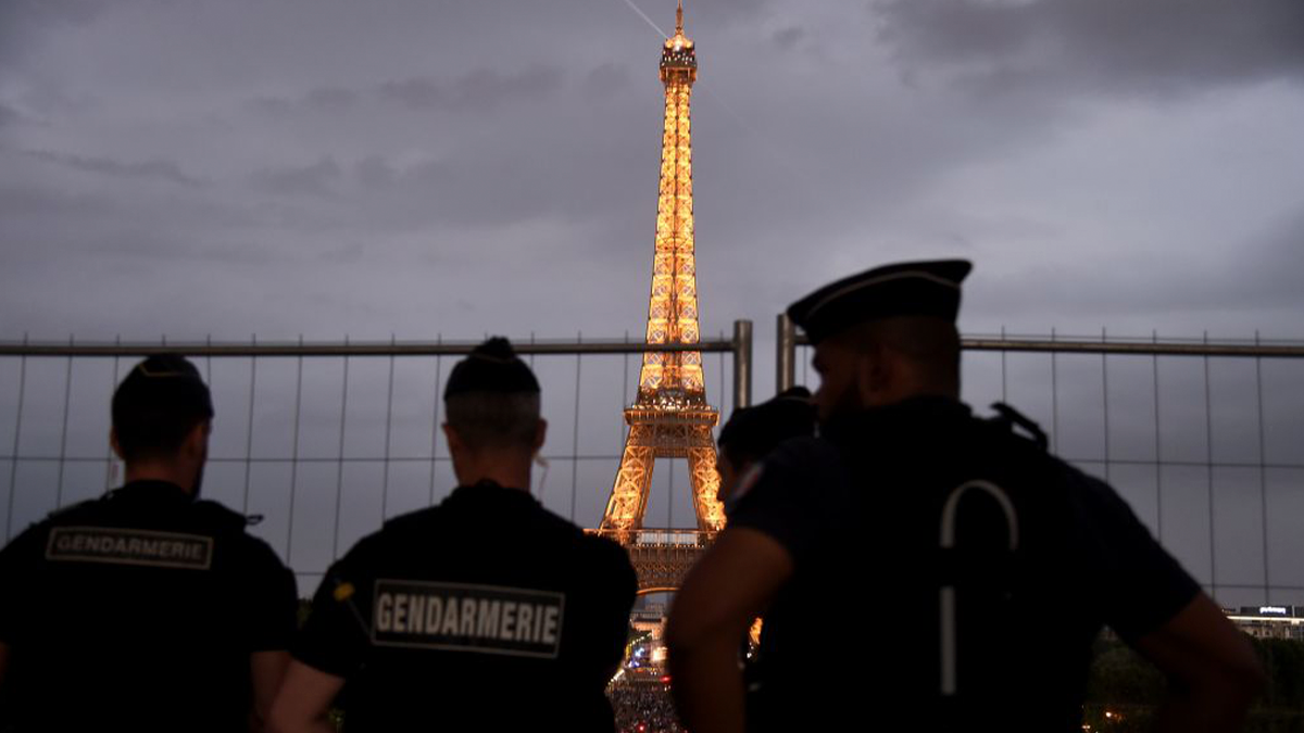 French gendarmes look towards the Eiffel Tower. GETTY IMAGES