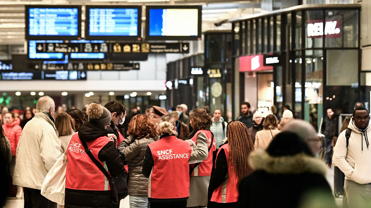 SNCF employees help commuters at the Gare de Montparnasse in Paris during a strike. GETTY IMAGES