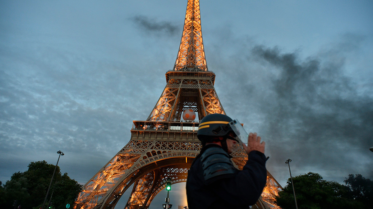 A French riot policeman stands at the foot of the Eiffel Tower. GETTY IMAGES