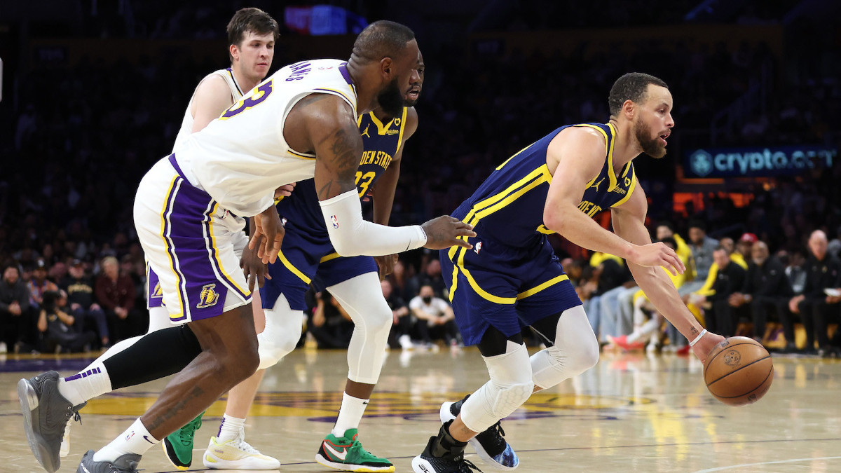 Stephen Curry #30 of the Warriors dribbles past the defence of LeBron James #23 of the Lakers. GETTY IMAGES