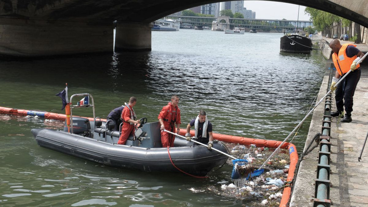 Members of the river brigade collect rubbish on the Seine near the Eiffel Tower. GETTY IMAGES