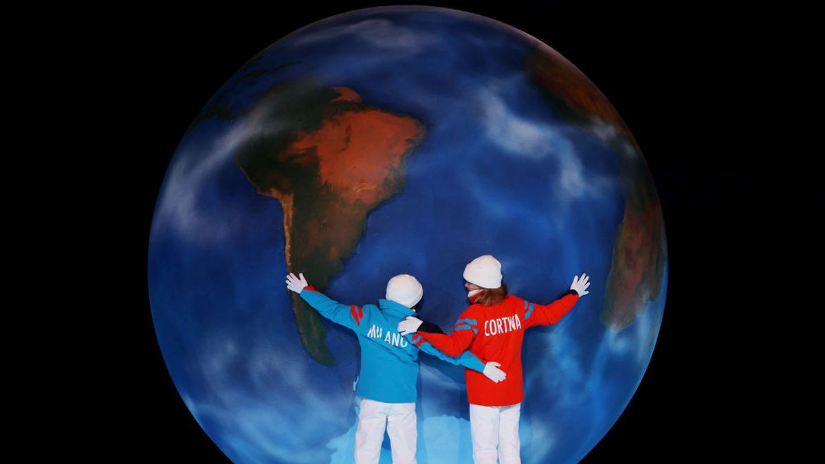 Children representing Milan and Cortina hug a globe as part of the handover ceremony during the Beijing 2022 Winter Olympics Closing Ceremony. GETTY IMAGES