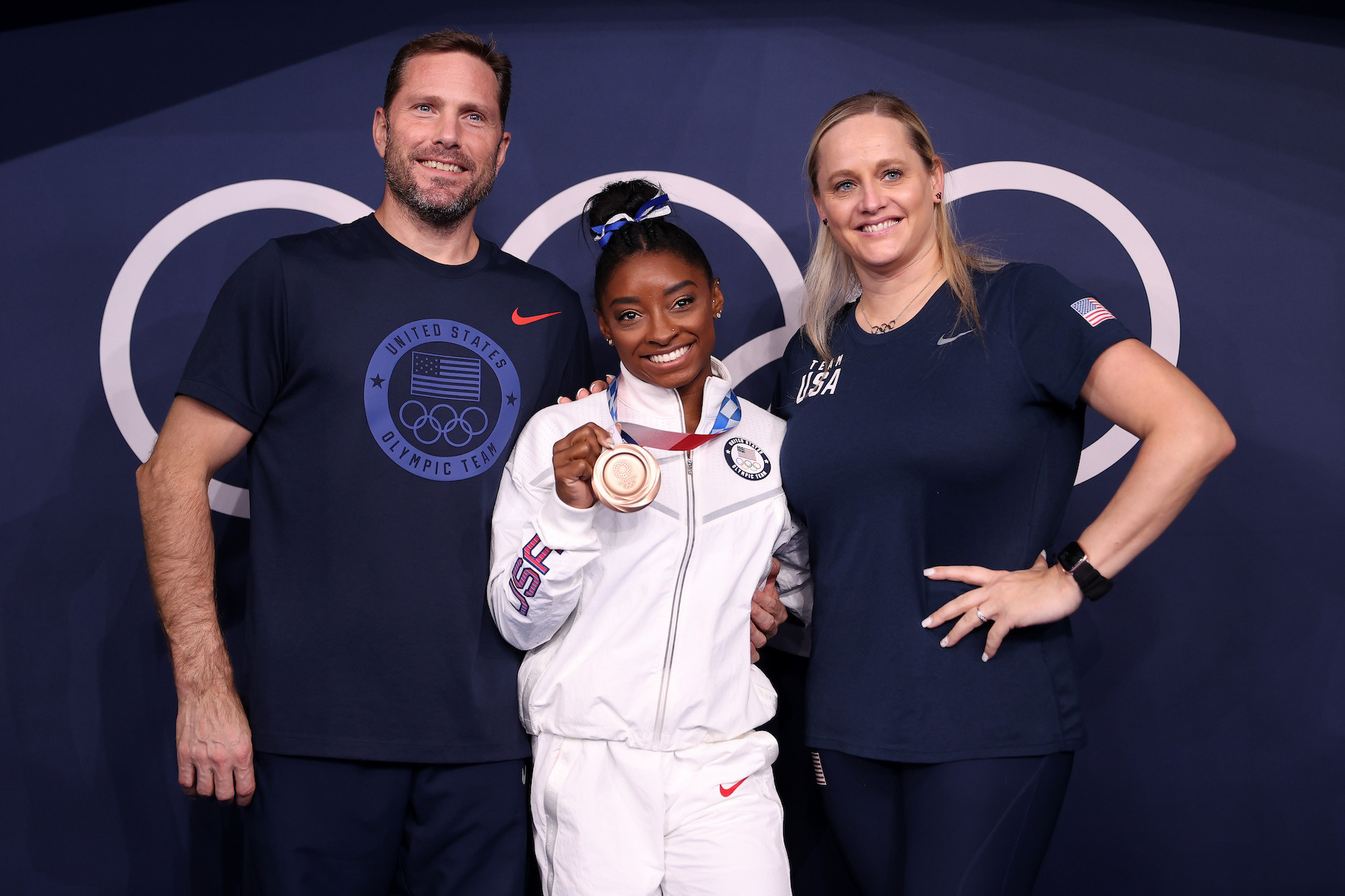 Cecile Canqueteau-Landi poses with bronze medalist Simone Biles and husband and co-coach Laurent Landi. GETTY IMAGES