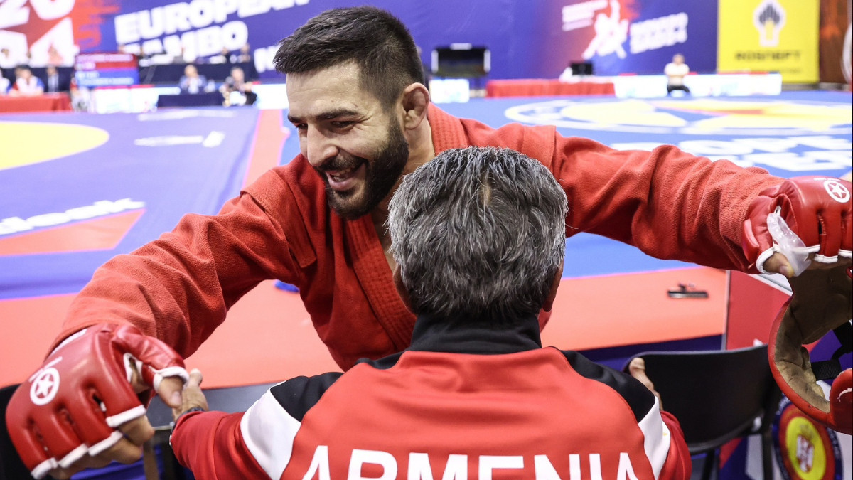 Armenia's Mayis Nersesyan celebrates his gold medal in the men's Combat SAMBO -64 kg category with his coach. FIAS